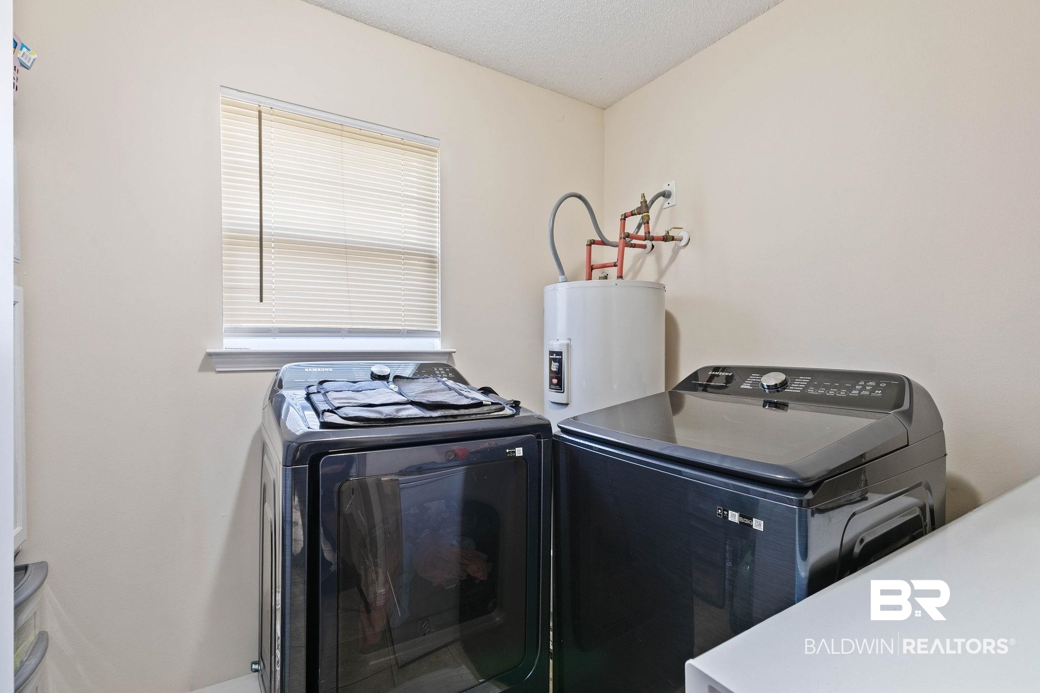 55750 Lottie Road Perdido, AL 36562 - Photo 41 of 84 Laundry area with washing machine and clothes dryer, water heater, and a textured ceiling