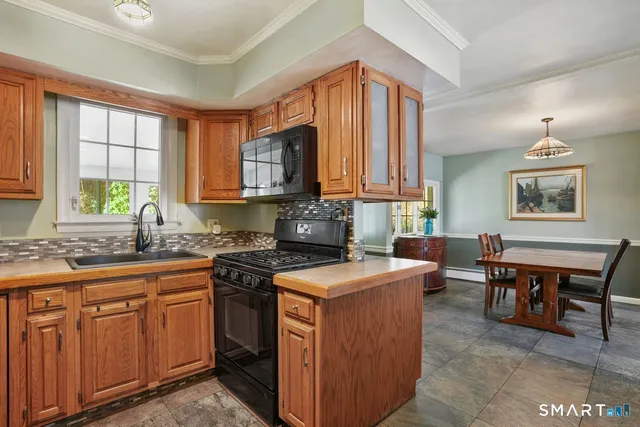 a kitchen with stainless steel appliances granite countertop a stove a sink dishwasher and a microwave oven with cabinets