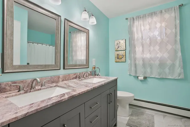 a bathroom with a granite countertop sink mirror and toilet