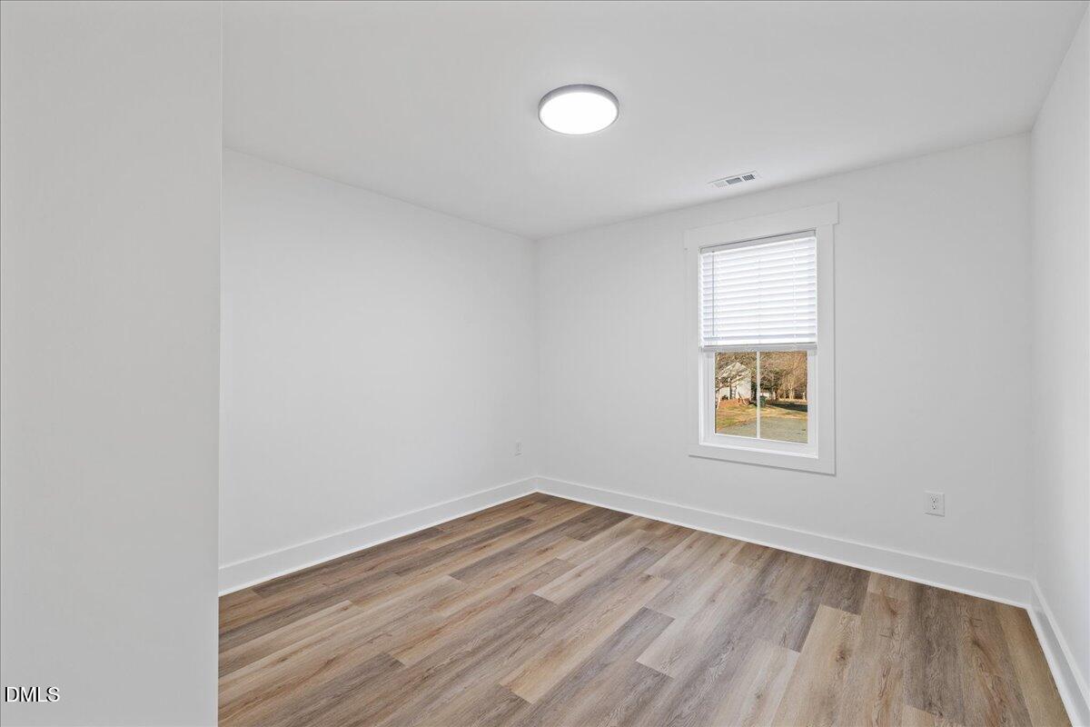 617 North 3rd Street Mebane, NC 27302 - Photo 35 of 50 an empty room with a window and wooden floor