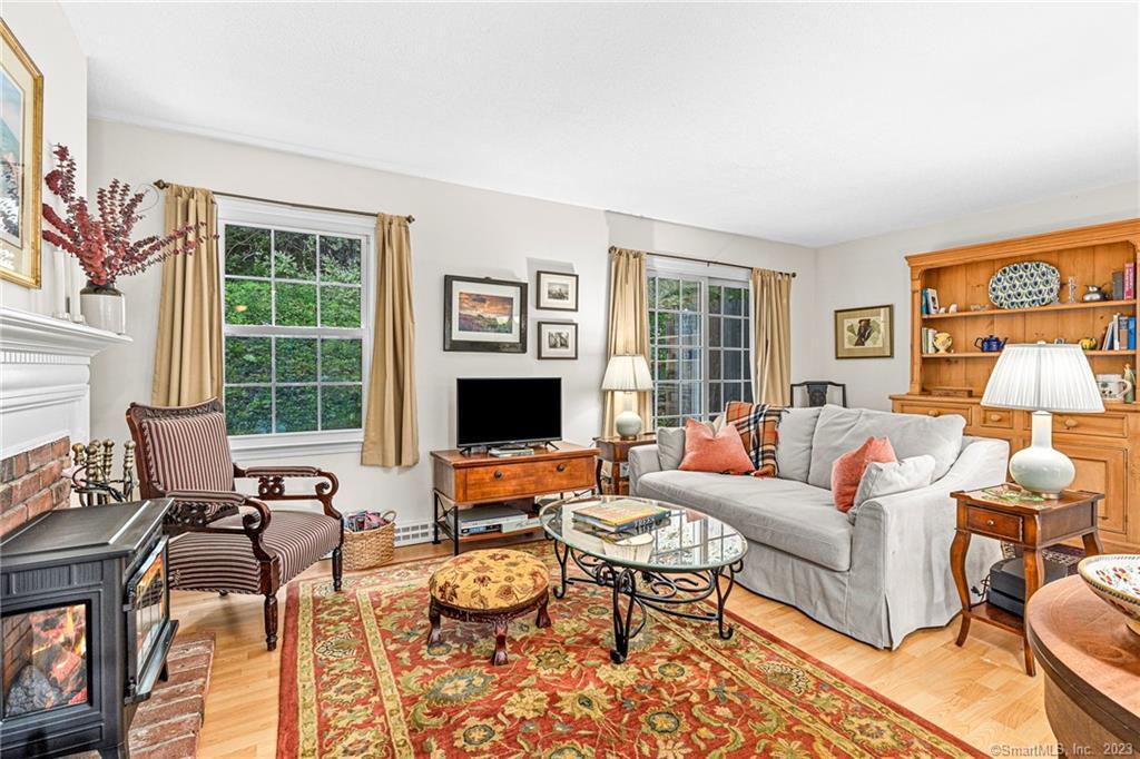 a living room with furniture flat screen tv and a large window