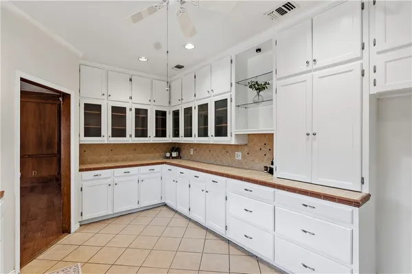 a large white kitchen with a sink and dishwasher with wooden floor