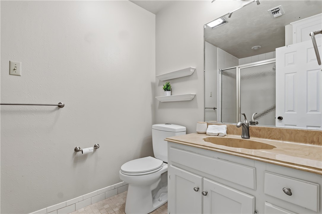 904 Bob White Street Bryan, TX 77802 - Photo 26 of 36 a bathroom with a granite countertop toilet sink and mirror