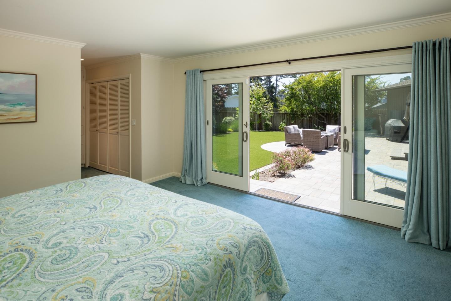 4117 Sunridge Road Pebble Beach, CA 93953 - Photo 21 of 46 a bedroom with a bed and glass door