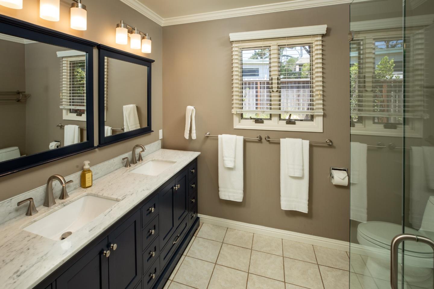 4117 Sunridge Road Pebble Beach, CA 93953 - Photo 22 of 46 a spacious bathroom with a double vanity sink a mirror and a shower
