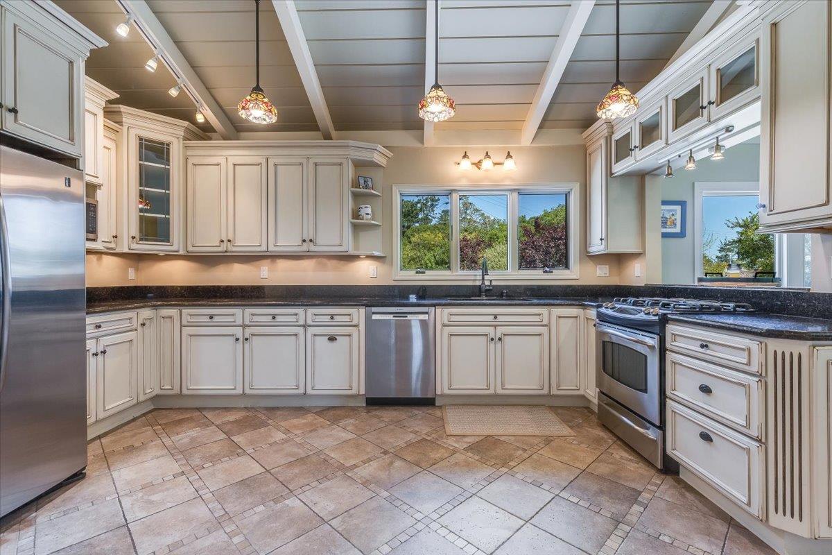 4117 Sunridge Road Pebble Beach, CA 93953 - Photo 9 of 46 a kitchen with kitchen island granite countertop a sink window and cabinets