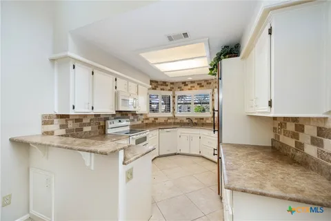 a kitchen with granite countertop a sink and cabinets