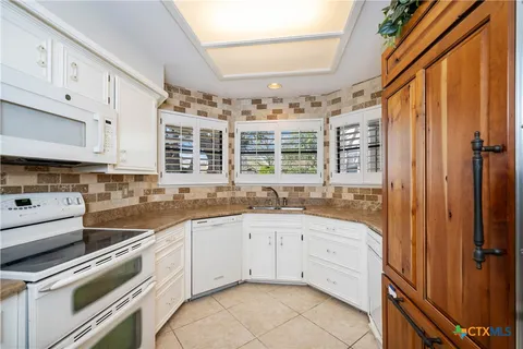 a kitchen with a sink stove and cabinets