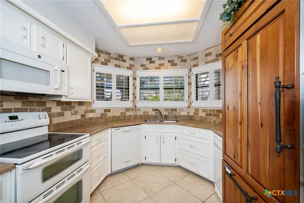 a kitchen with a sink stove and cabinets
