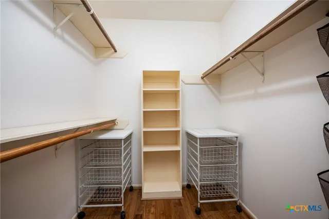 a view of walk in closet with empty racks