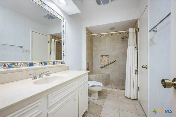 a bathroom with a sink a toilet and shower