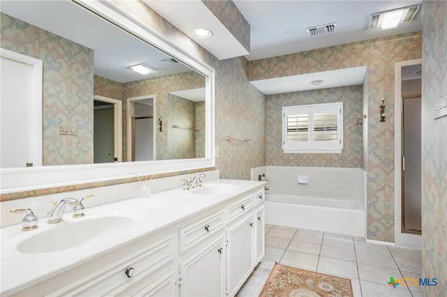 a bathroom with a tub a sink and a mirror