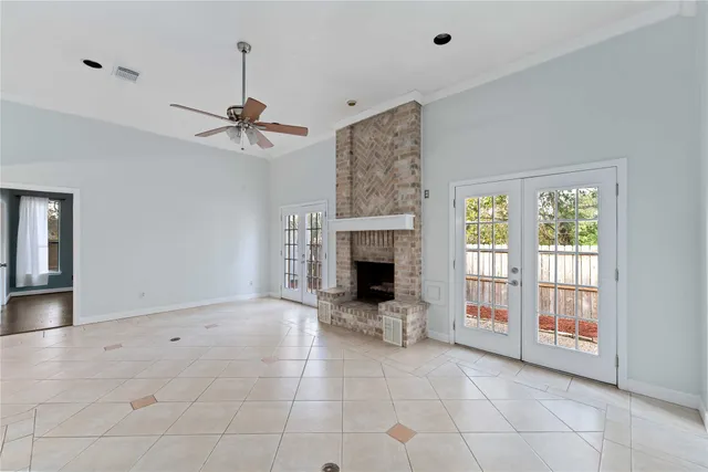 a view of an empty room with a ceiling fan and window