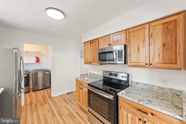 a kitchen with granite countertop a sink cabinets and stainless steel appliances