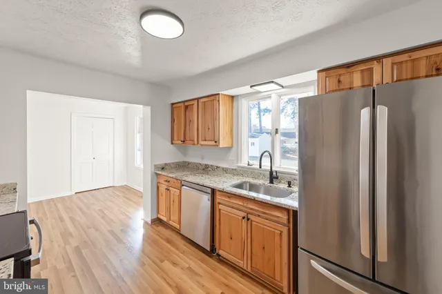 a kitchen with stainless steel appliances granite countertop a refrigerator sink and cabinets