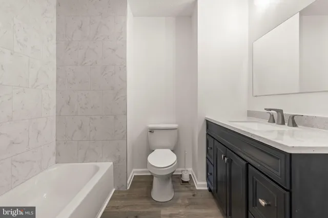 a bathroom with a granite countertop toilet a sink and bathtub