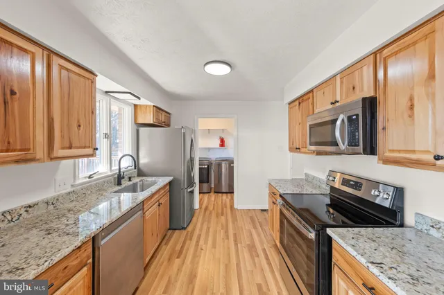 a kitchen with stainless steel appliances granite countertop a sink stove and oven