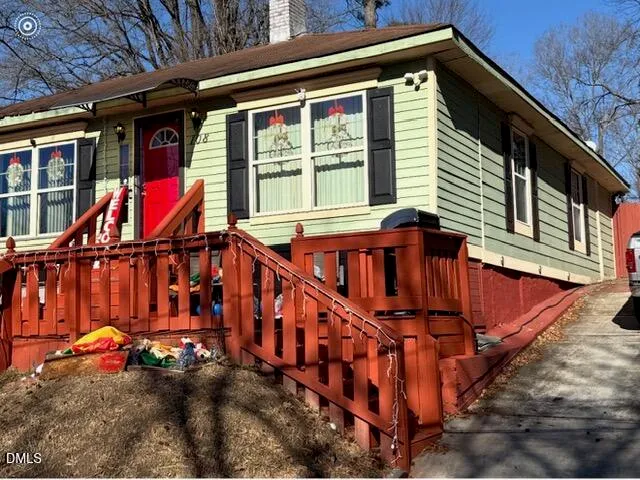 a view of a house with wooden stairs and a small yard