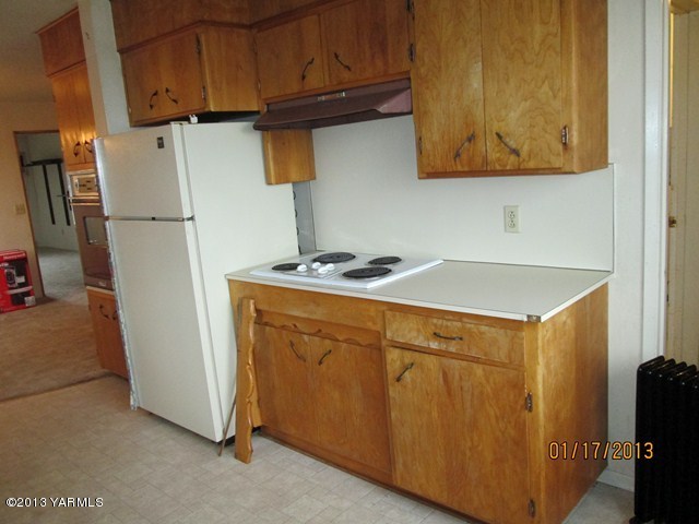 110 Charvet Road Grandview, WA 98930 - Photo 3 of 9 a kitchen with stainless steel appliances wooden cabinets and a refrigerator