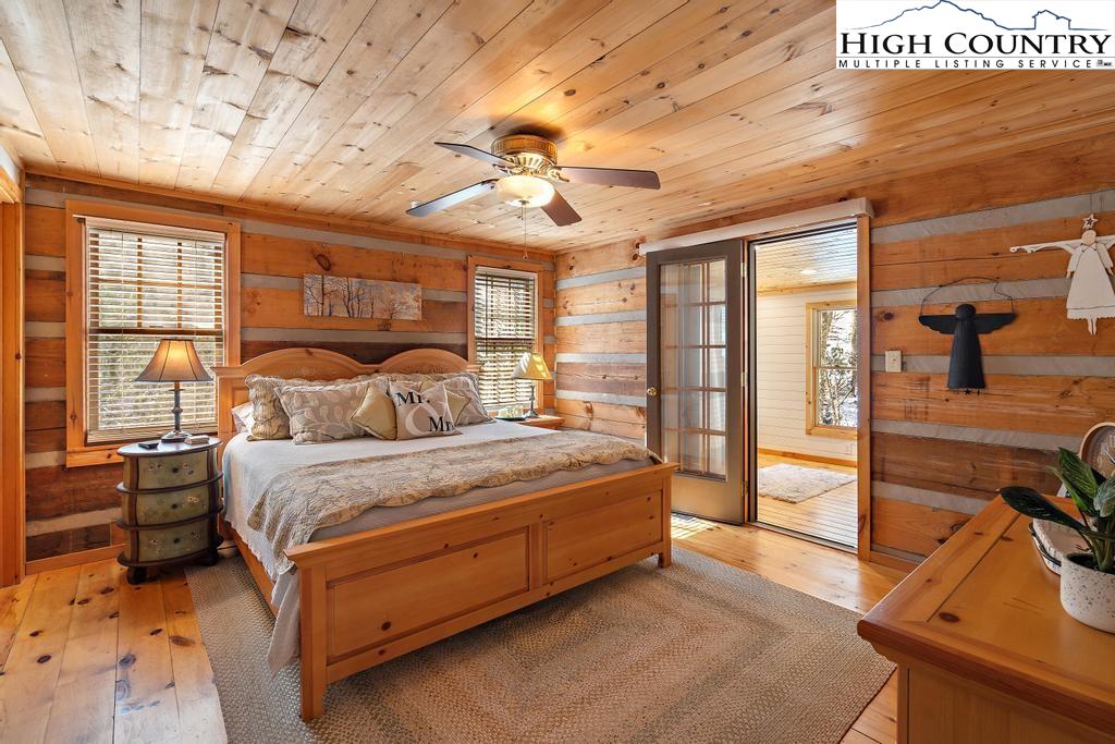 3855 Howard's Creek Road Boone, NC 28607 - Photo 20 of 38 a spacious bedroom with a bed a ceiling fan and a large window