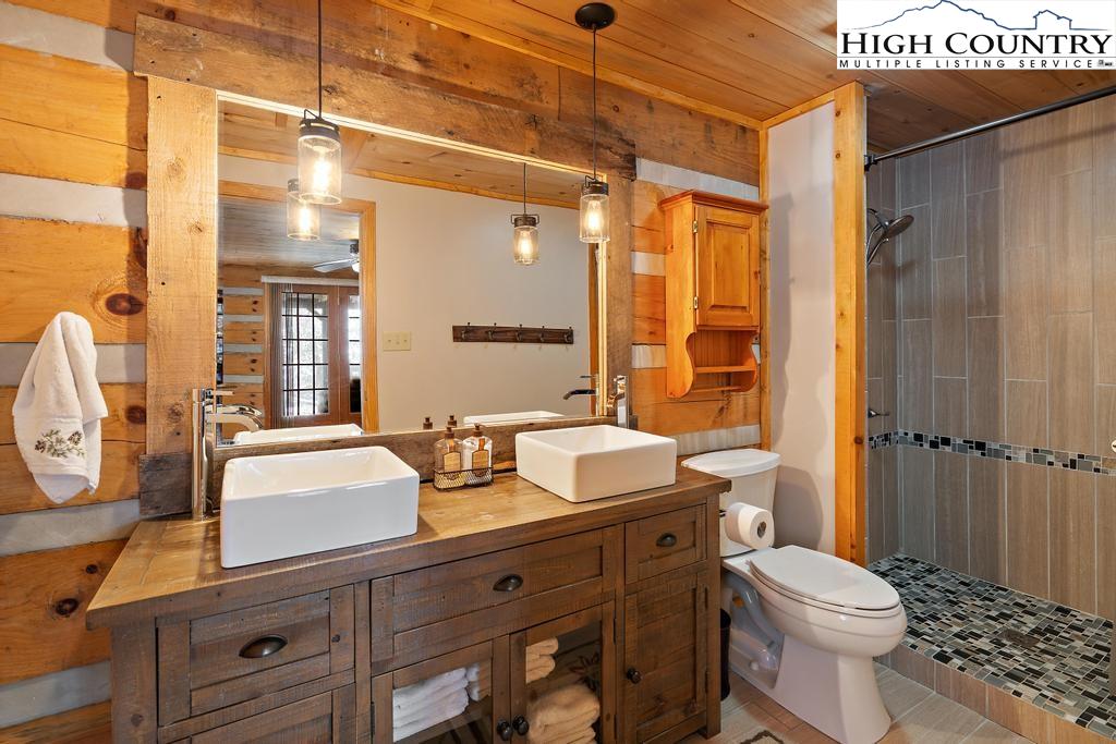 3855 Howard's Creek Road Boone, NC 28607 - Photo 27 of 38 a bathroom with a sink a toilet and shower