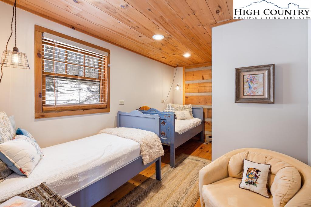 3855 Howard's Creek Road Boone, NC 28607 - Photo 28 of 38 a bedroom with a bed and wooden floor