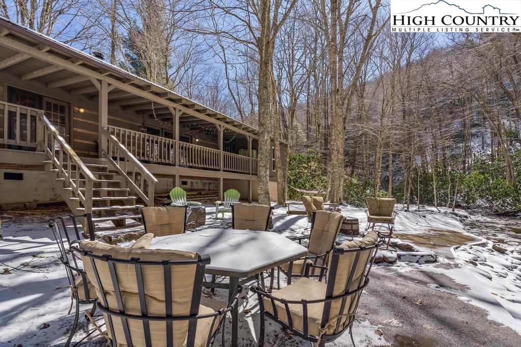 3855 Howard's Creek Road Boone, NC 28607 - Photo 34 of 38 a view of a patio with table and chairs with wooden floor and fence