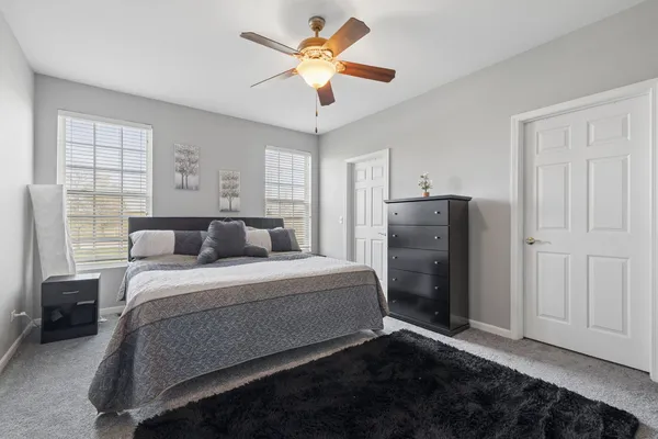 a bed room with a bed and a ceiling fan