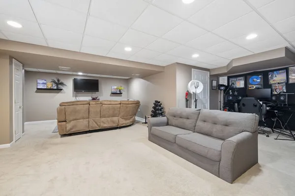a living room with furniture and a gym machine