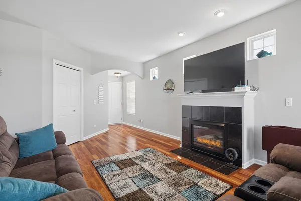 a living room with furniture a flat screen tv and a fireplace