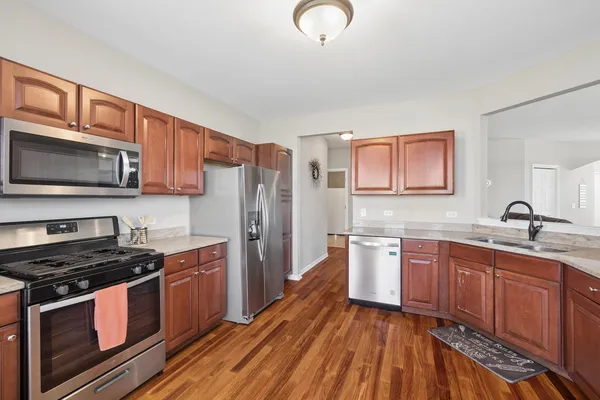 a kitchen with stainless steel appliances granite countertop a stove refrigerator sink and microwave