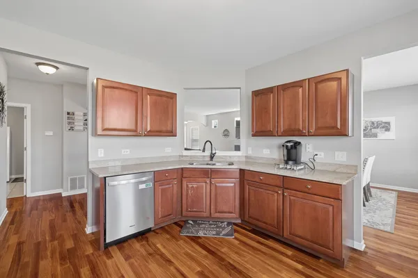 a kitchen with stainless steel appliances granite countertop a sink stove and wooden floor