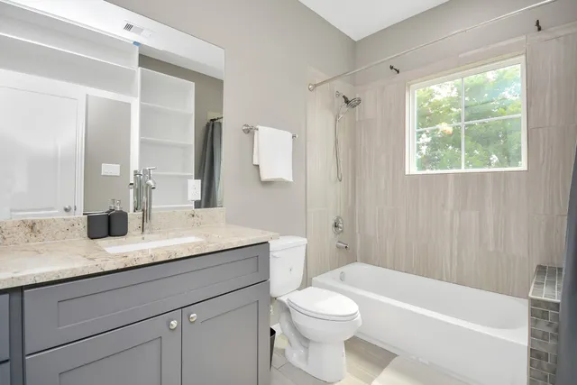 a bathroom with a granite countertop sink toilet and shower