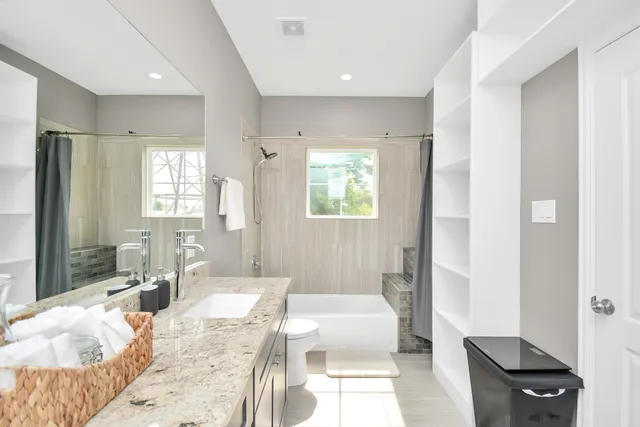 a large bedroom with a bed and wooden floor