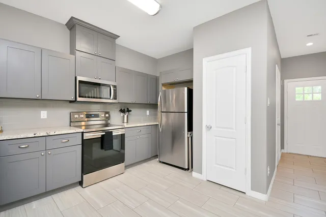 a kitchen with stainless steel appliances granite countertop a refrigerator and a stove top oven