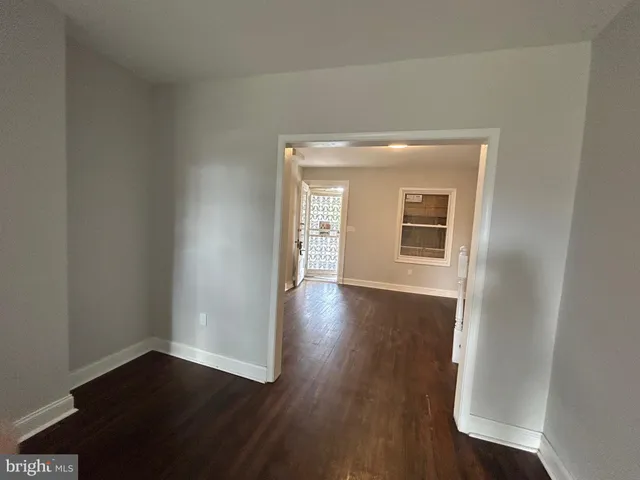 a view of a hallway with wooden floor and a window
