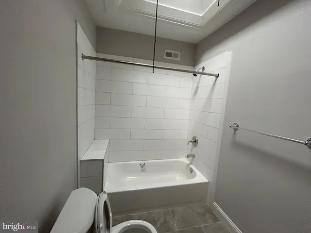 a bathroom with a bathtub a toilet and a shower