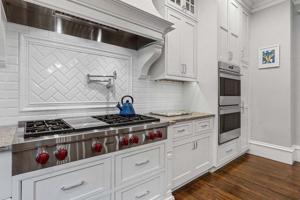 3 Ravine Road Winchester, MA 01890 - Photo 15 of 42 a kitchen with white cabinets and a stove top oven