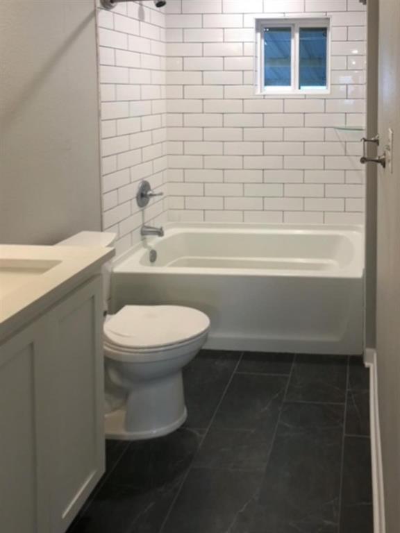 602 West 3rd Street Justin, TX 76247 - Photo 11 of 22 Bathroom featuring white subway tile surround, white bathtub/shower combination, dark tile flooring, and a window above the tub