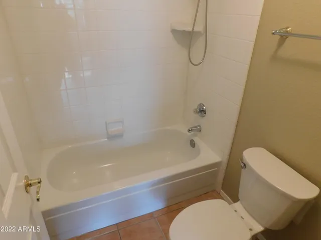 a white toilet sitting next to a bath tub