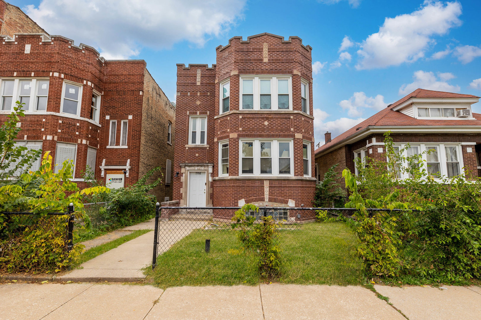 7752 South Wood Street, Unit 1 Chicago, IL 60620 - Photo 1 of 12 a front view of a residential apartment building with a yard