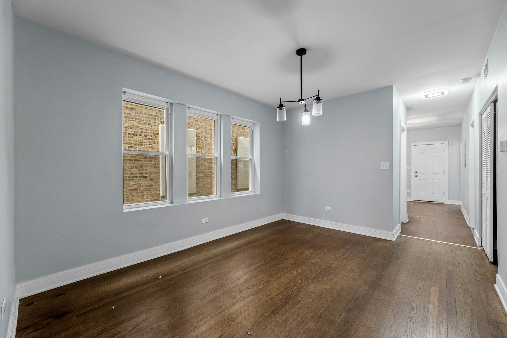 7752 South Wood Street, Unit 1 Chicago, IL 60620 - Photo 4 of 12 a view of an empty room with a window and wooden floor