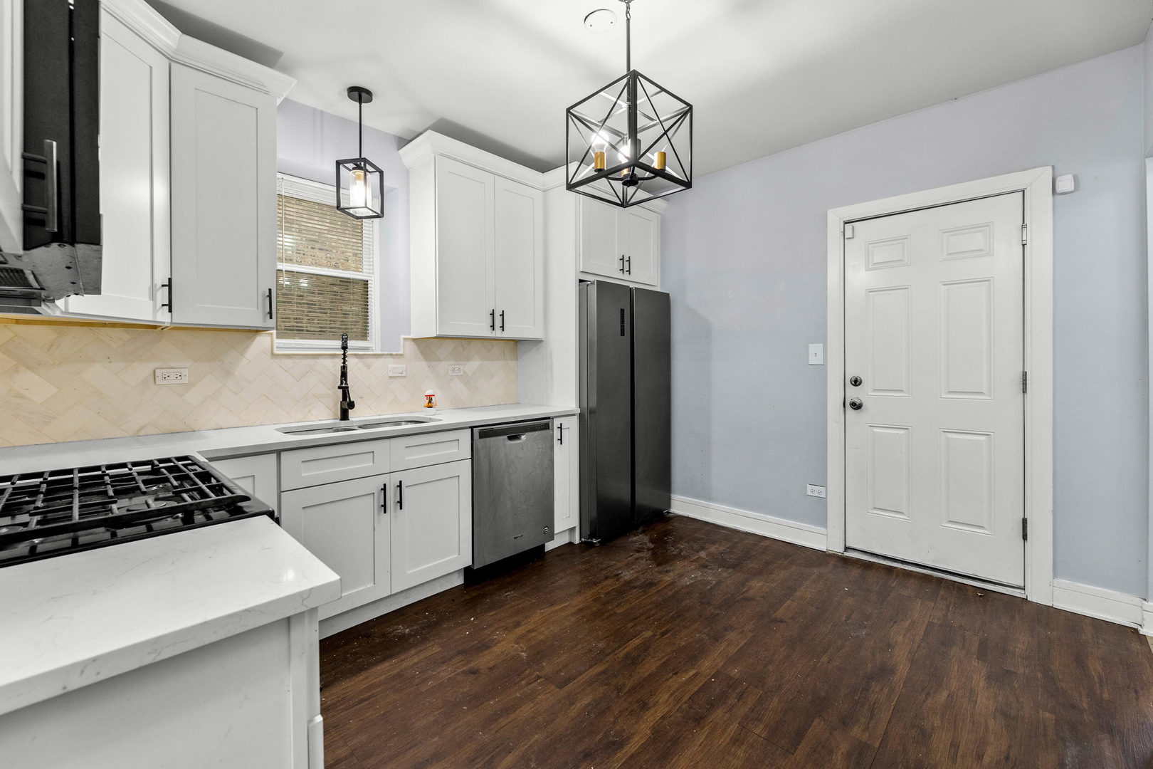 7752 South Wood Street, Unit 1 Chicago, IL 60620 - Photo 8 of 12 a kitchen with stainless steel appliances a refrigerator a sink dishwasher a stove and white cabinets with wooden floor