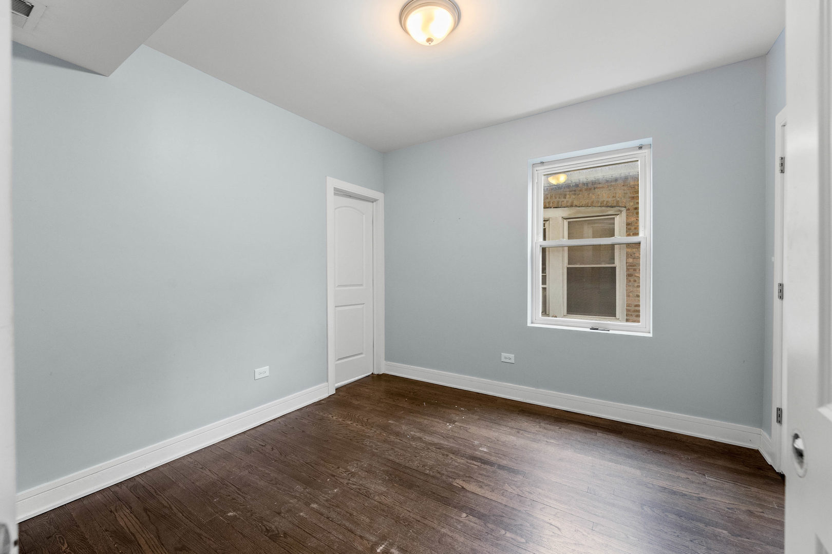 7752 South Wood Street, Unit 1 Chicago, IL 60620 - Photo 10 of 12 an empty room with wooden floor and windows