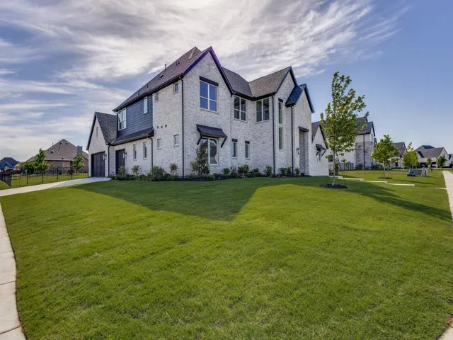 a view of a house with a big yard and large trees
