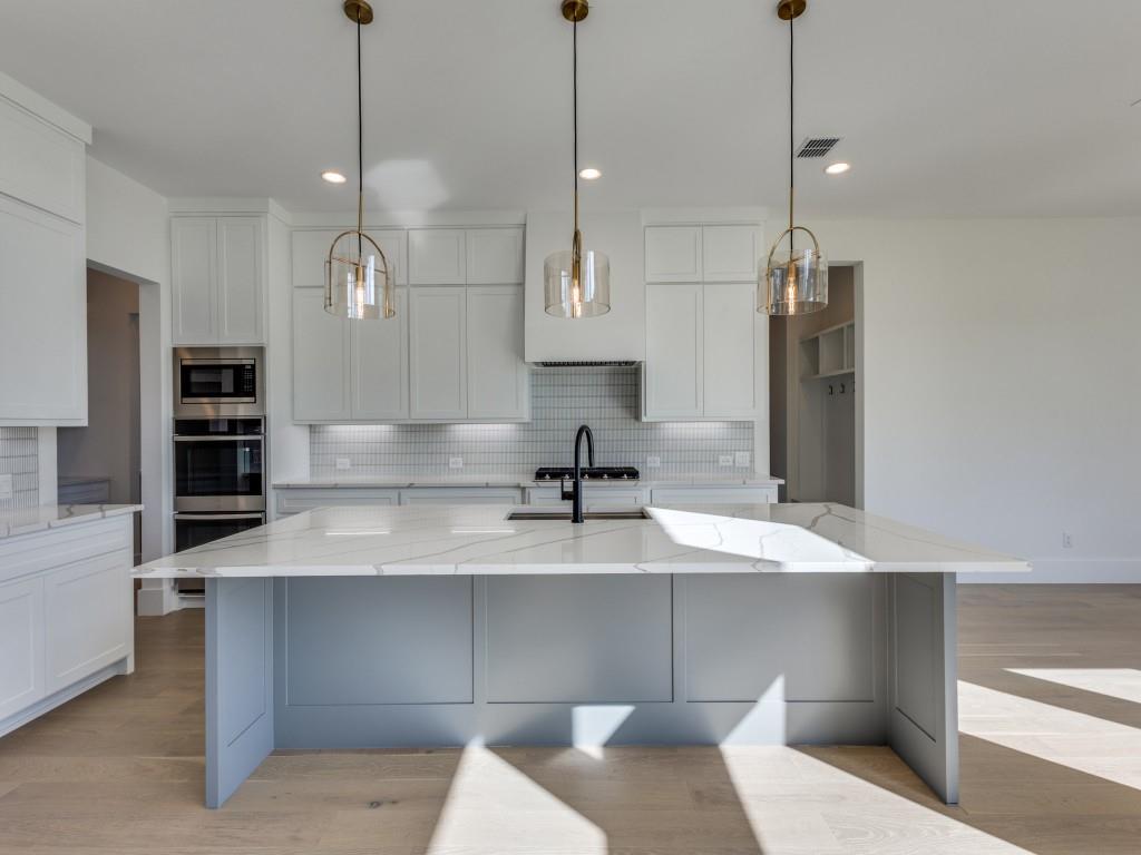 1045 Bent Tree Lane Gunter, TX 75058 - Photo 5 of 25 a view of a kitchen with kitchen island a sink stainless steel appliances and a chandelier