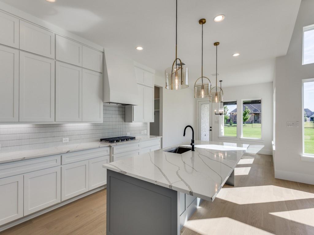 1045 Bent Tree Lane Gunter, TX 75058 - Photo 6 of 25 a kitchen with stainless steel appliances granite countertop a sink a stove and a wooden floors