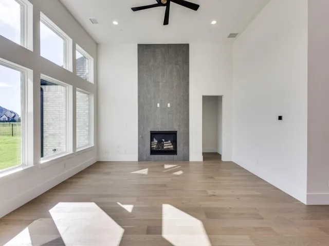 a view of an empty room with a window and kitchen view