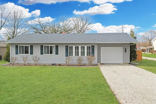 a front view of a house with a garden and yard