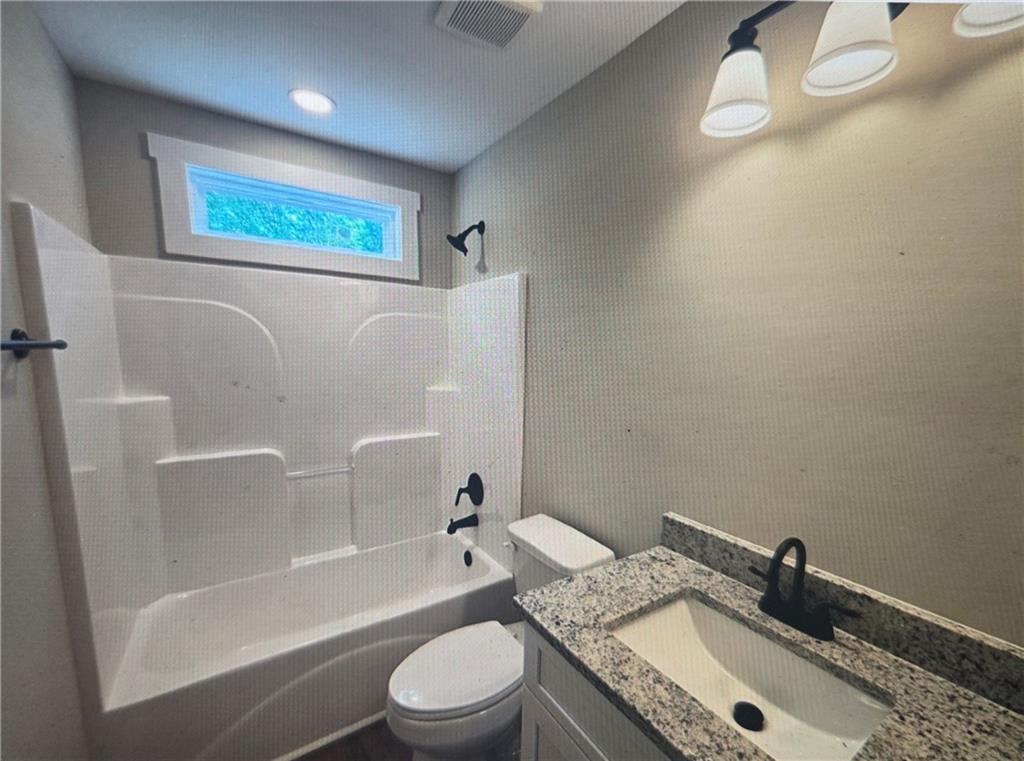 816 Forrest Avenue Rockmart, GA 30153 - Photo 16 of 18 a bathroom with a granite countertop sink a toilet and bathtub